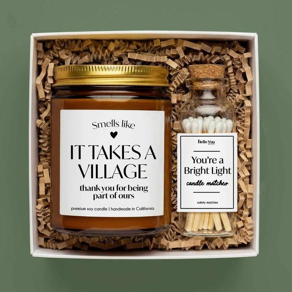 Thank you gift candle in a box with matches, labeled "It Takes a Village" for expressing gratitude.